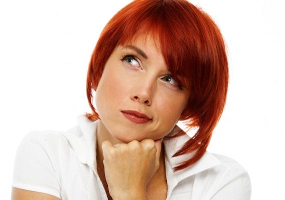 Frau schaut nachdenklich nach oben rechts – Symbol für positiven ersten Eindruck und Kundenvertrauen