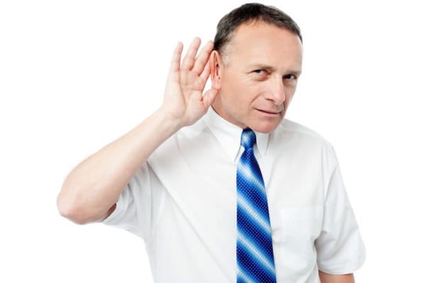 Mann mit Krawatte lauscht – Kundenumfragen für Marketingstrategie in der Schweiz