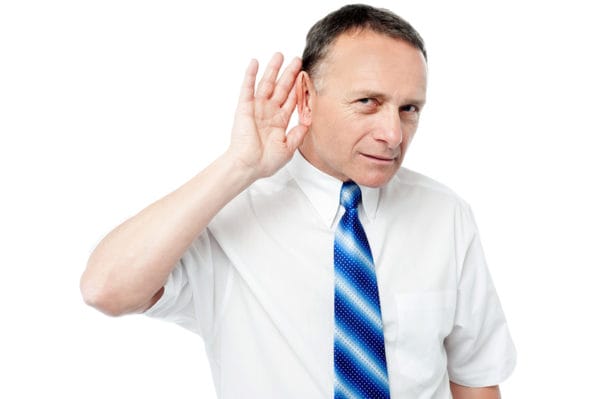 Mann mit Krawatte lauscht – Kundenumfragen für Marketingstrategie in der Schweiz