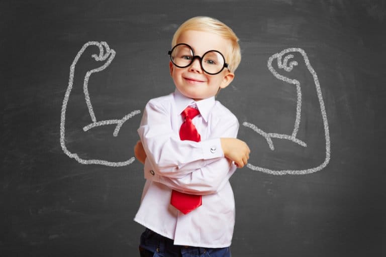 Junger Bube steht stolz vor einer Wandtafel mit zwei muskulösen Armen – Symbol für Erfolg und Netzwerkaufbau