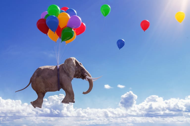 Ein Elefant wird von bunten Luftballons in die Luft gehoben – Symbol für Selbstmotivation, Leichtigkeit und die Kraft positiver Gedanken.
